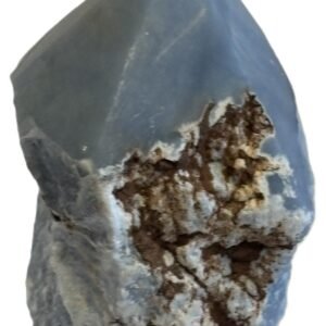 Natural rough angelite freeform with polished point 3 sians emporium Natural rough angelite freeform crystal with unpolished sides and a smooth polished blue point standing on a white background
